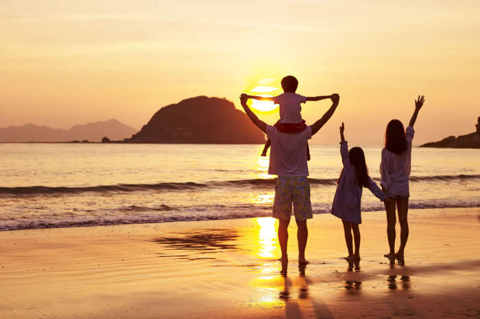 a family on beach during sunset