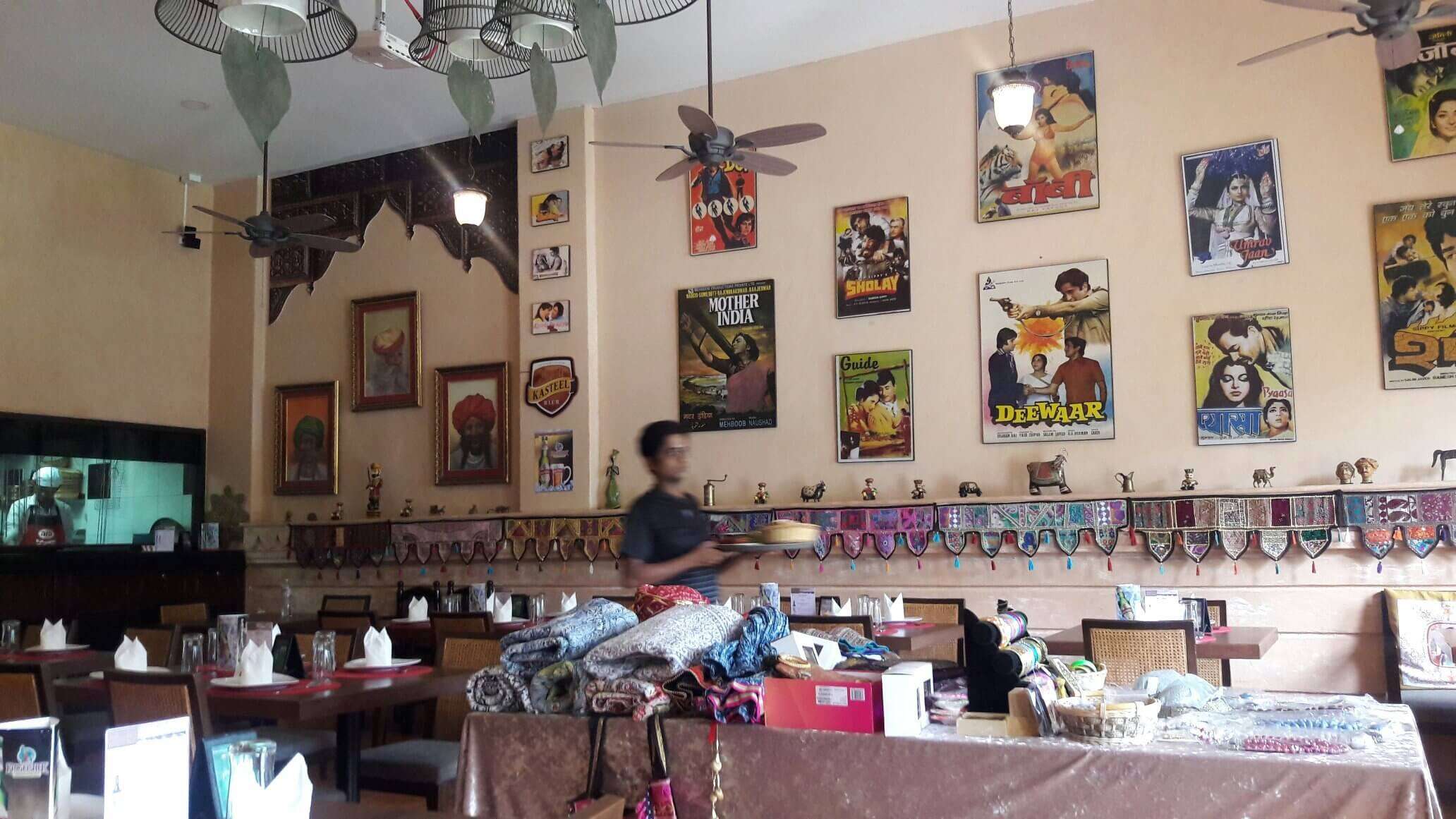 Bollywood theme restaurant with pictures of hindi movies hung on wall