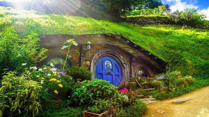 a hobbiton house with blue door