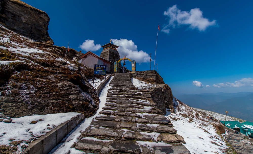 rock steps through snowy trails to a temple