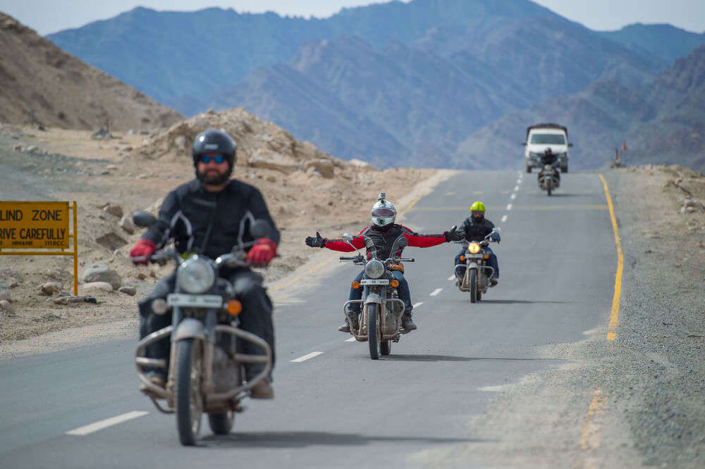 men riding bike on the roads of ladakh