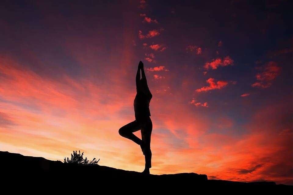 a person doing yoga during sunset
