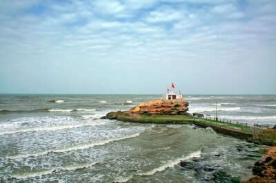 the temple is surrounded by blue waters, golden sand