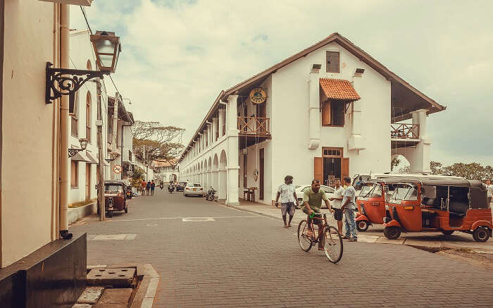 a man cycling in an old town of Sri Lanka