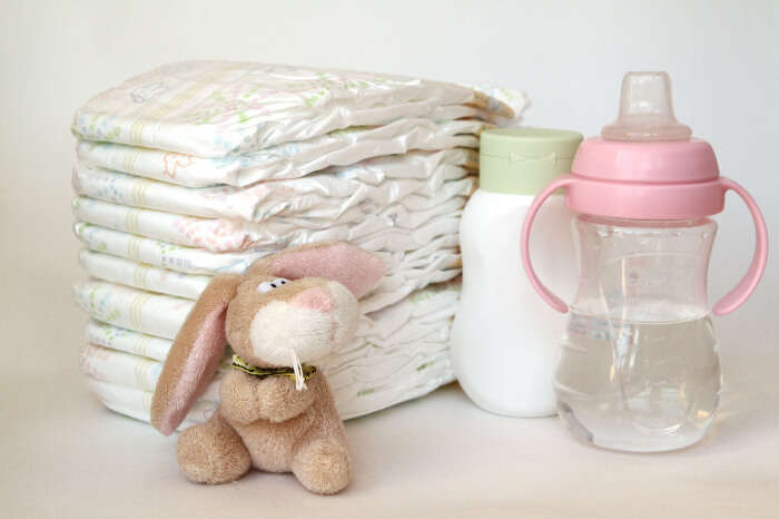 Baby essentials including diapers, water & milk bottles, and a toy