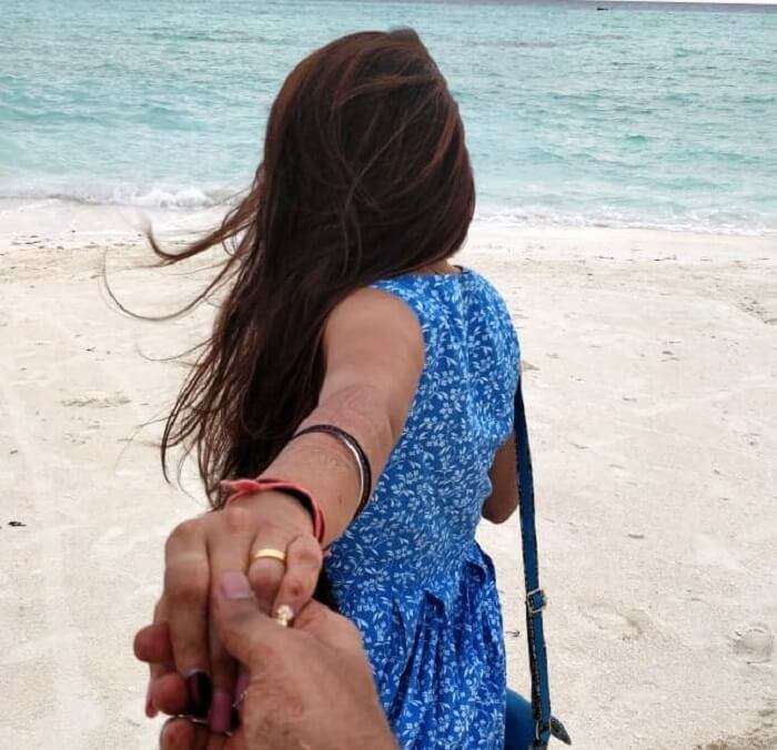 man holding woman's hand on beach