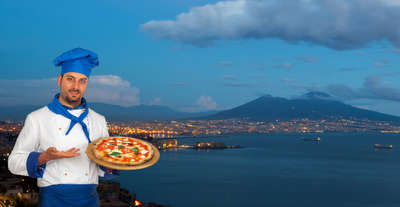 A chef holding pizza in Naples, Italy