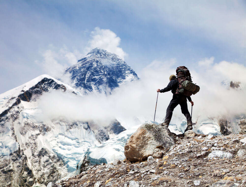 A man is trekking in snow covered mountains