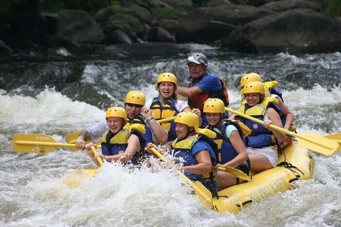 people rafting on a rapid stream