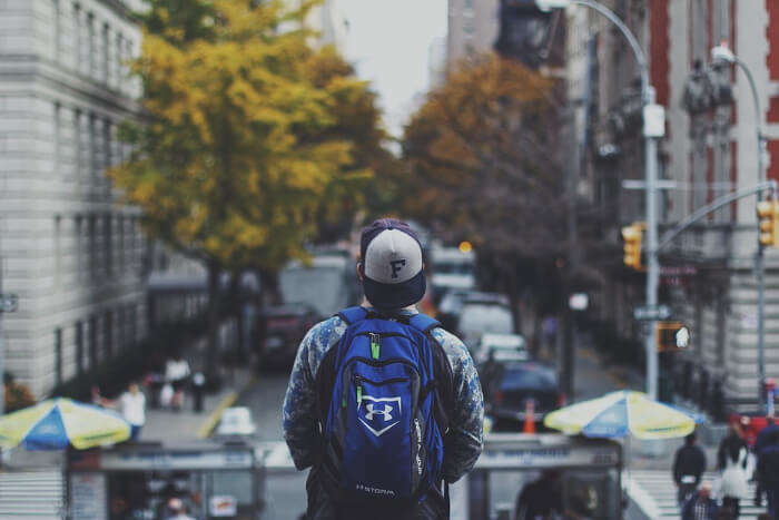 A backpacker watching the city traffic