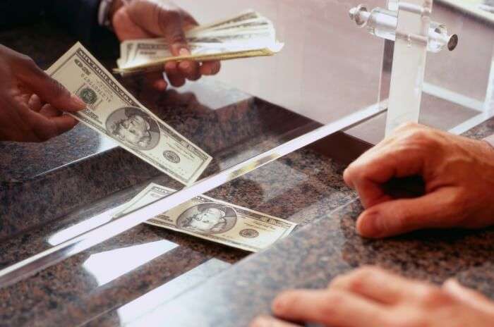 Bank Teller Counting Money for Customer