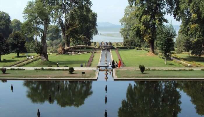 people near a pond in a Shalimar garden which is one of the top places to visit in Kashmir