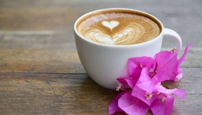 Coffee on a table with pink flower petals