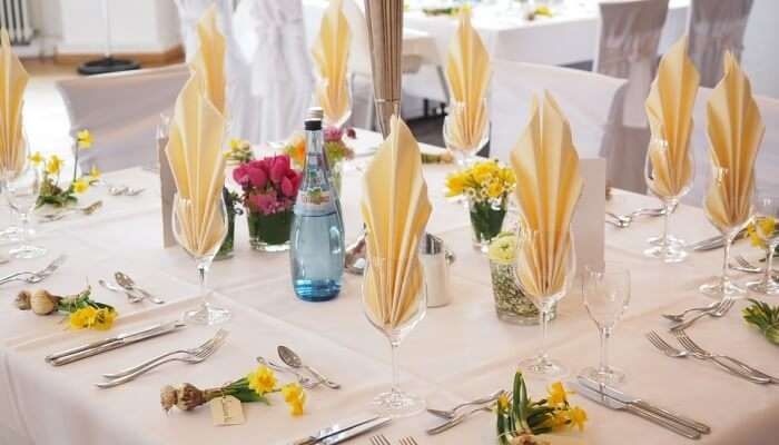 table with glasses, plates, and culinary decorated with flowers 