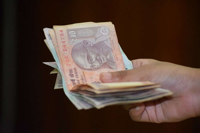 Man distributing rupee notes