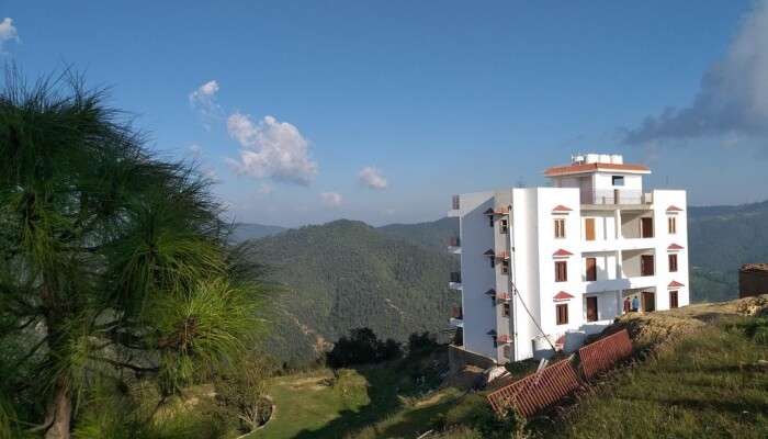 white building amidst green mountains