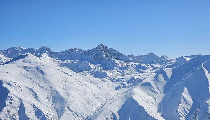 Visit Apharwat Peak in Gulmarg in summer or winter.