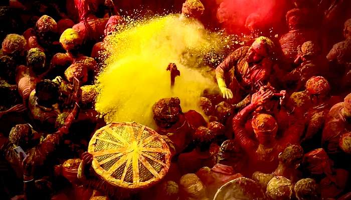 Crowds of people playing with colours during holi in mathura