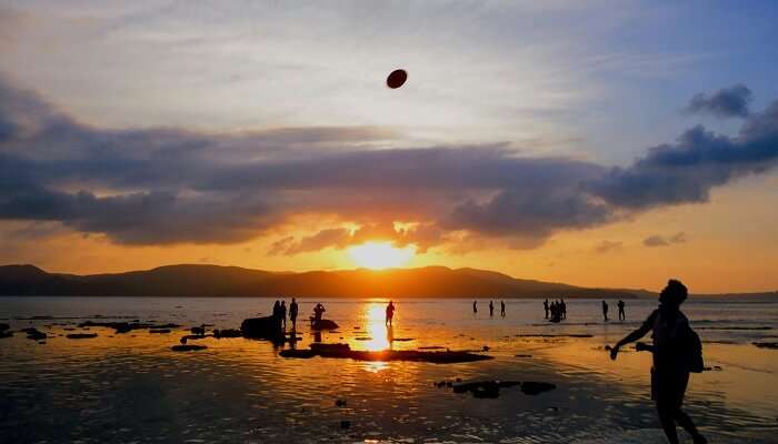 Tourists enjoying sunset at Andaman beach, illustrating the island’s serene beauty.