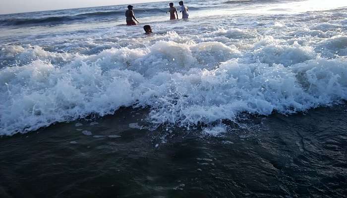 People playing in water in Blangad beach- one of the stunning places near Guruvayur.