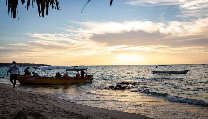 A Boat on the Seashore with People