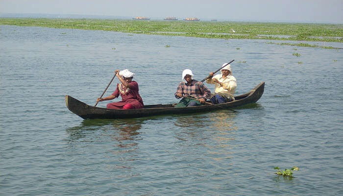 A group of people sailing a country boat in Kerala.
