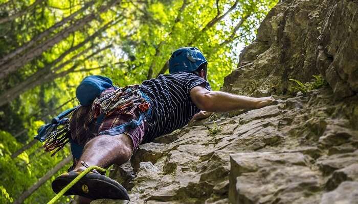 Man rock climbing adventure sports in Munnar rocky cliffs