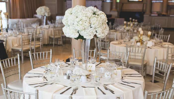 A wedding dinner with a white flower in front. 