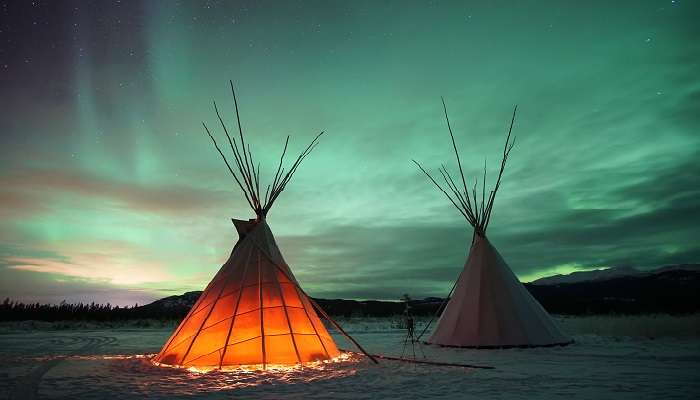 Tipies indiens sous les aurores boréales à Whitehorse au Yukon