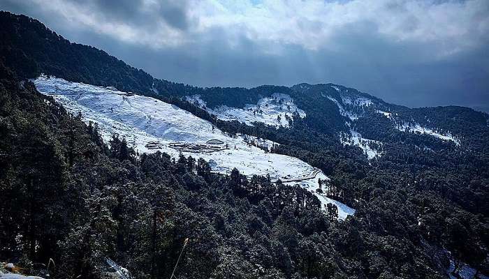 View of Chopta camping site with the Himalayan mountains in the background 