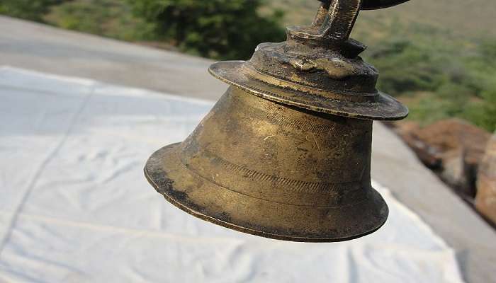 Bronze bells hanging in the Koteshwar Mahadev temple