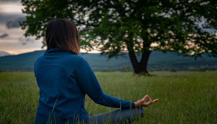 woman meditating near liril falls