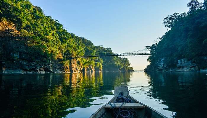 A man performing Kayaking on the river during sunrise