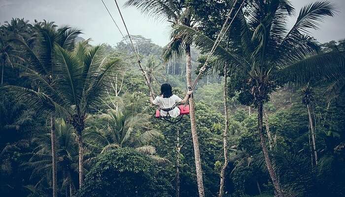 Female in red dress enjoying the Bali Swing 