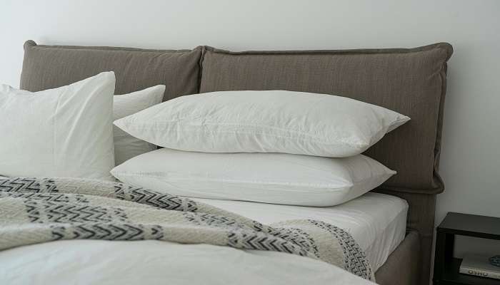 A white linen-covered bed in a hotel room to stay.