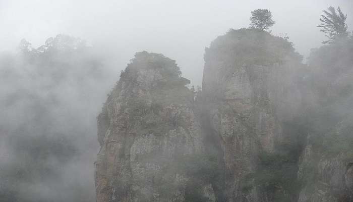 Mist covering Pillar Rocks in Tamil Nadu.