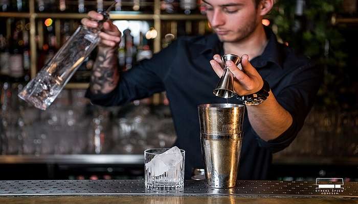 A bartender preparing a drink in a pub