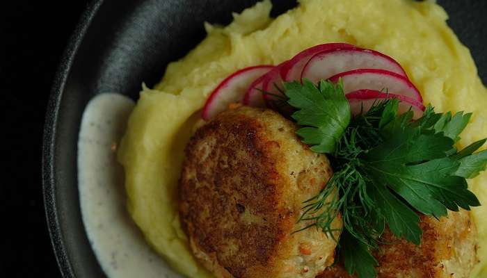 Top view of a dish with mashed potato and meat.