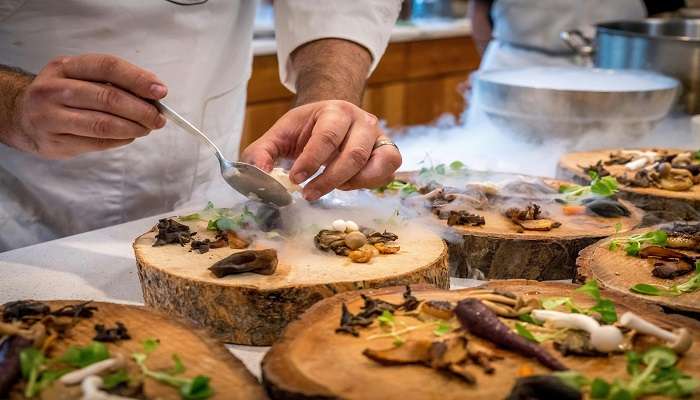 Chef Preparing Vegetable Dish on Tree Slab at the best Restaurants in Lismore.