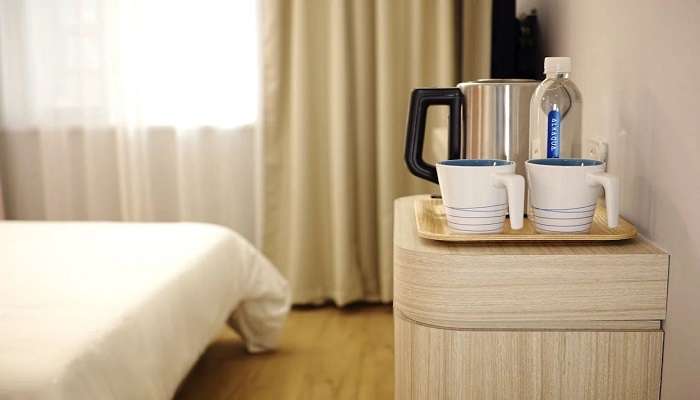 A hotel room with two white ceramic mugs on a brown wooden tray, Hotels In Villivakkam