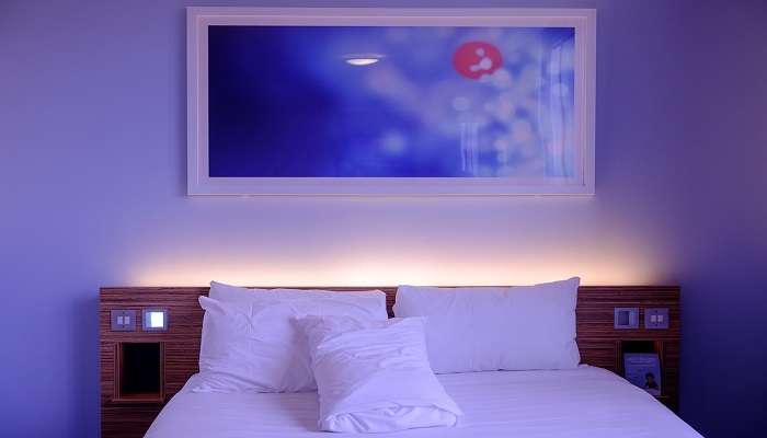 Hotel bedroom with queen size bed and mood lighting.