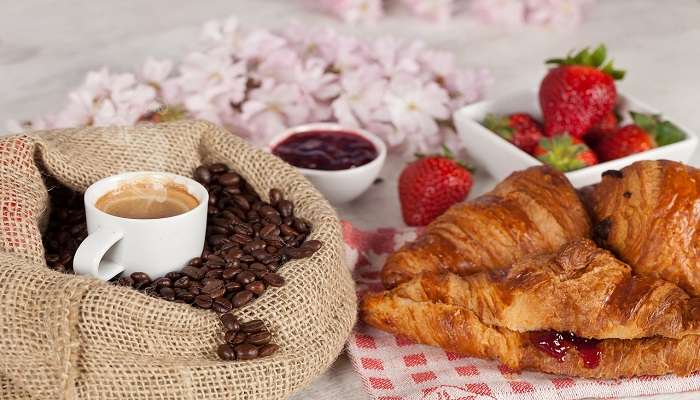 Freshly baked croissants with jam and a cup of coffee.