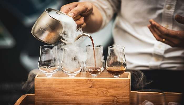 Person pouring fresh coffee in a glass