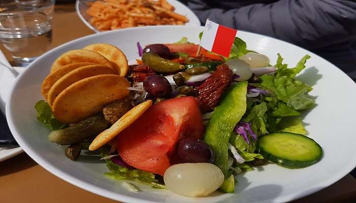 A freshly prepared Maltese dish served on a plate to try in Blue Grotto