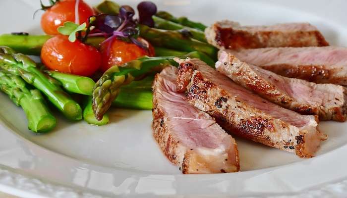 A plate of steak with asparagus 