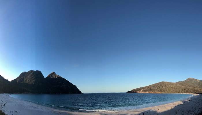 Aerial view of Wineglass Bay in Freycinet National Park with pristine beaches, turquoise waters, and surrounding mountains.