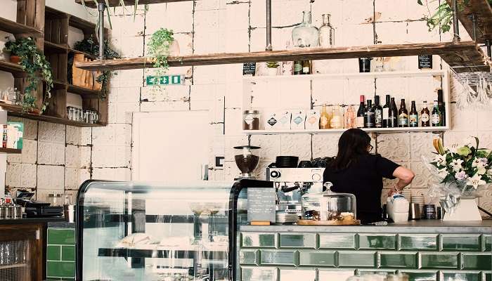 A woman preparing a cup of coffee at the best cafes in Tamworth.