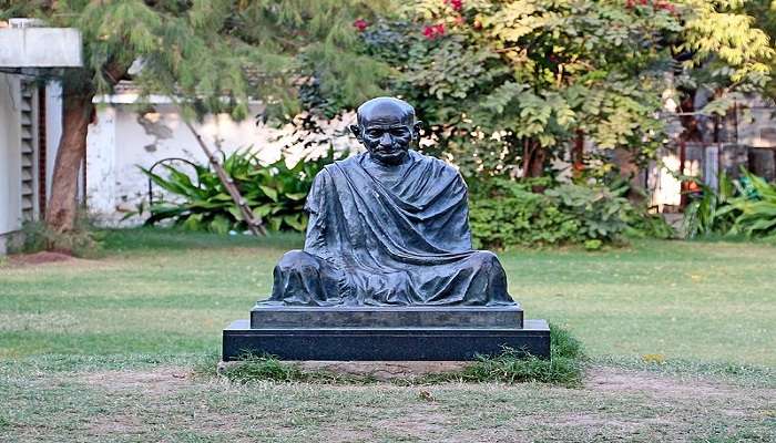 Mahatma Gandhi’s statue at the Sabarmati Ashram in Gujarat to visit near the The Calico Museum Of Textiles.