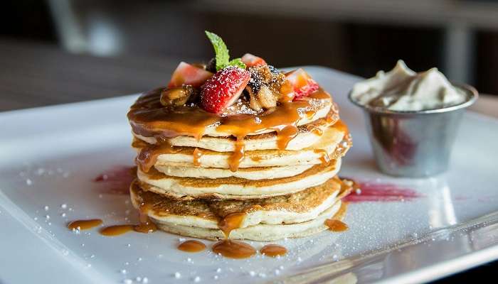 A plate of pancake with strawberry at the top cafes in Bunbury.