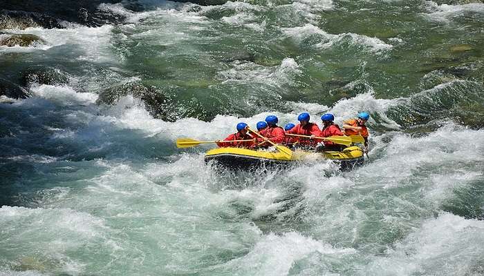 8 people on a river raft in the river Sesia flowing down the Dolomites